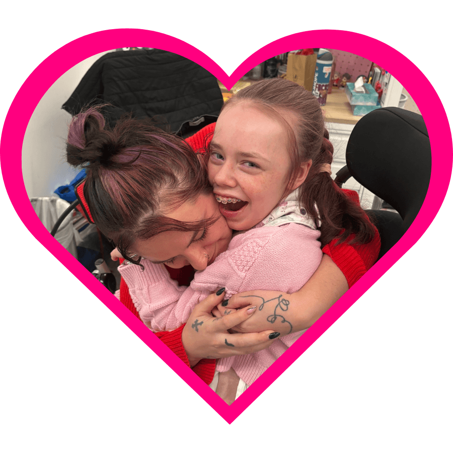 iHOPE student smiling and hugging a staff member. 